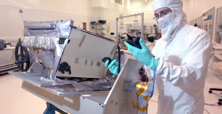 Operatore in tuta sterile al lavoro in una camera bianca